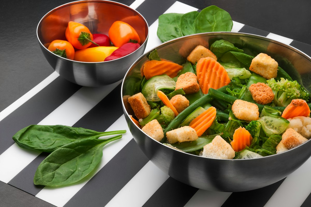 Mangkuk hijau sayur segar dengan crouton tahu panggang